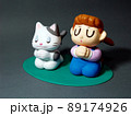 目を閉じ手を合わせ願い事をする女の子と猫 89174926
