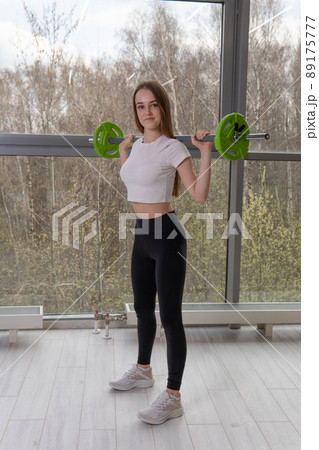 Smiles a The barbell in hands her with girl barbell strong fit woman, for heavy fitness from gym and training sportswear, holding abandoned. Sports beautiful dumbbell, girl adult active Smiles a The barbell in hands her with girl barbell strong fit woman, for heavy fitness from gym and training sportswear, holding abandoned. Sports beautiful dumbbell, girl adult active 89175777