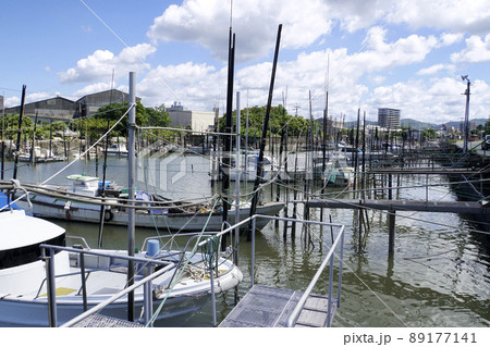 青空の白い雲と大牟田川に係留された漁船 89177141
