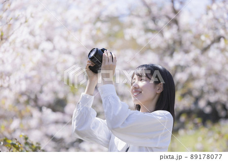 カメラで花の写真を撮る若い女性 カメラで花の写真を撮る若い女性 89178077