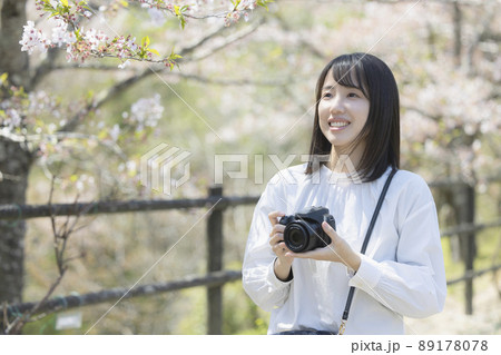 カメラで花の写真を撮る若い女性 89178078