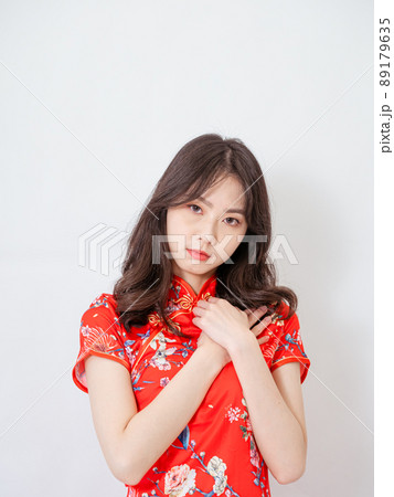 Young asian woman wearing traditional cheongsam qipao dress with hands on chest over isolated white background. 89179635