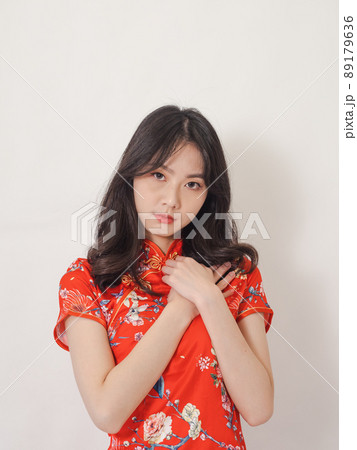 Young asian woman wearing traditional cheongsam qipao dress with hands on chest over isolated white background. 89179636