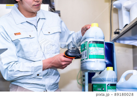 業務用キッチンで薬品の在庫を確認する作業員のイメージカット 89180028