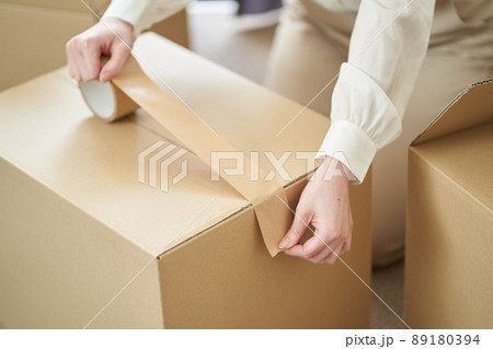 ダンボールにガムテープを貼るアジア人女性 89180394