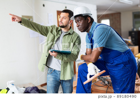 Two men talking on indoor construction site 89180490