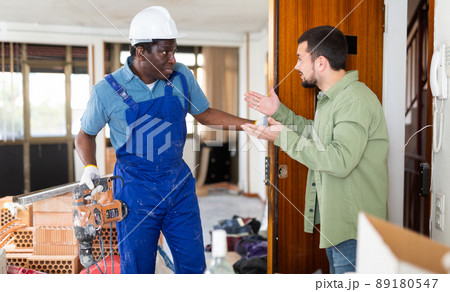 Focused builders posing on indoor construction site 89180547