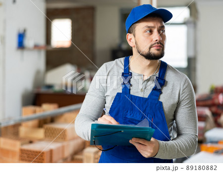 Qualified builder writes notes on a tablet Qualified builder writes notes on a tablet 89180882