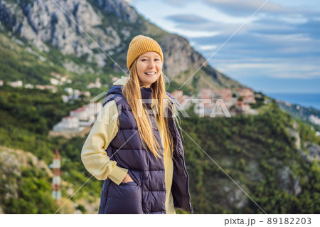 Woman in the mountains of Montenegro in warm clothes. Travel to Montenegro in spring, autumn, winter 89182203