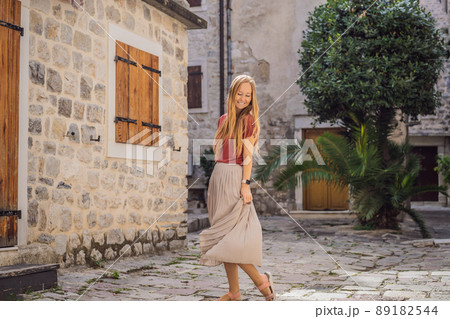 Woman tourist enjoying Colorful street in Old town of Kotor on a sunny day, Montenegro. Travel to Montenegro concept 89182544