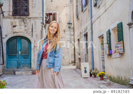 Woman tourist enjoying Colorful street in Old town of Kotor on a sunny day, Montenegro. Travel to Montenegro concept Woman tourist enjoying Colorful street in Old town of Kotor on a sunny day, Montenegro. Travel to Montenegro concept 89182585