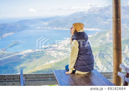 Woman tourist enjoys the view of Kotor. Montenegro. Bay of Kotor, Gulf of Kotor, Boka Kotorska and walled old city. Travel to Montenegro concept. Fortifications of Kotor is on UNESCO World Heritage 89182664