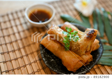 Tasty Asian vegetables spring rolls on a minimal black plate 89182900