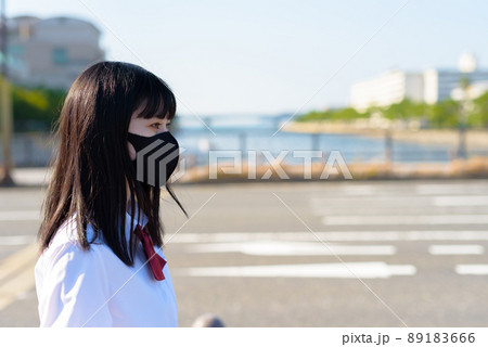 夕日を背に布マスクして自転車を押す、自転車通学する女子高校生 住宅地 市街地 明暗 夕日を背に布マスクして自転車を押す、自転車通学する女子高校生 住宅地 市街地 明暗 89183666