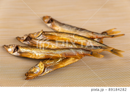 Smoked capelin against a beige background. Five ready-to-eat little fish. Seafood. Smoked capelin against a beige background. Five ready-to-eat little fish. Seafood. 89184282
