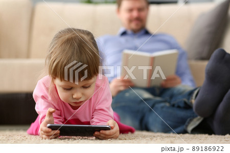 Little girl kid watching cartoon on smartphone device, digital entertainment for child Little girl kid watching cartoon on smartphone device, digital entertainment for child 89186922