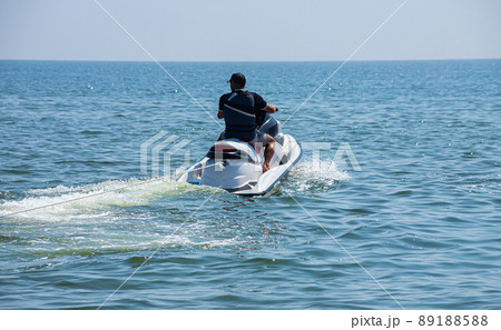 Teen age boy skiing on water scooter. Young man on personal watercraft in tropical sea. Active summer vacation for school child. Sport and ocean activity on beach holiday 89188588