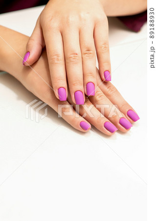 Beautiful manicure with purple, pink nail polish on young caucasian female hands 89188930