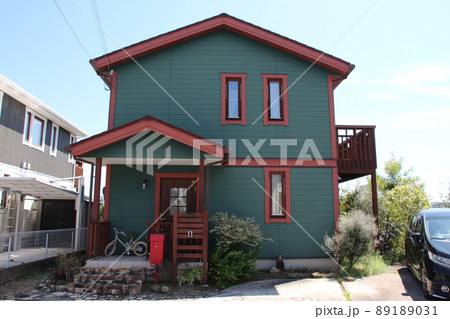 青空に映える深いグリーンと趣のある赤のコントラストが美しくオシャレでかわいく素敵な北欧風の邸宅 89189031