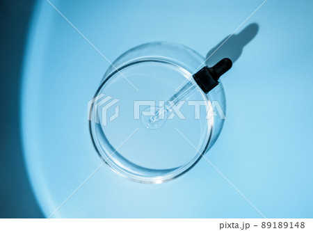 Laboratory glass petri with pipette and drop of water, serum, oil, beauty product. Natural medicine, cosmetic research, bio science. Concept of skincare and analysis. Dermatology. Flat lay, top view 89189148
