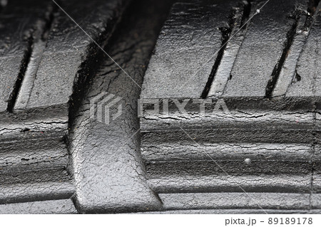 Old worn black tire with many large cracks in the car wheel. 89189178