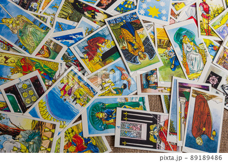 Background with pile of the tarot cards, the major arcana deck. Fortune telling seance or black magic ritual. Scary still life with occult and esoteric symbols. Halloween or divination rite Background with pile of the tarot cards, the major arcana deck. Fortune telling seance or black magic ritual. Scary still life with occult and esoteric symbols. Halloween or divination rite 89189486