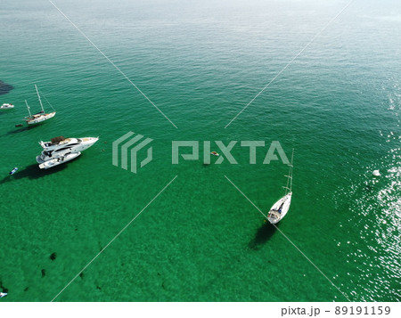 Aerial panoramic view of seascape with crystal clear azure sea and rocky shores. Yachts in a beautiful lagoon on backdrop of rocks. The concept of an ideal destination for summer travel and vacation. Aerial panoramic view of seascape with crystal clear azure sea and rocky shores. Yachts in a beautiful lagoon on backdrop of rocks. The concept of an ideal destination for summer travel and vacation. 89191159