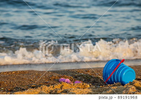 Children's toys on a sandy beach, blue sky and the sea in the background Children's toys on a sandy beach, blue sky and the sea in the background 89191968