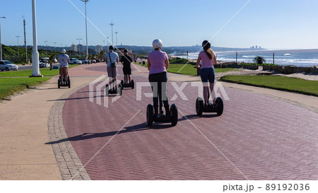 People Riding Stand Up Scooters Beach Ocean People Riding Stand Up Scooters Beach Ocean 89192036