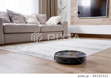 Robotic vacuum cleaner on the floor in cozy modern living room 89192422