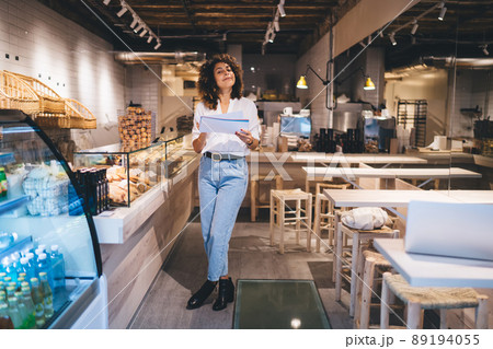 Full length portrait of self employed woman accounting in grocery service industry 89194055