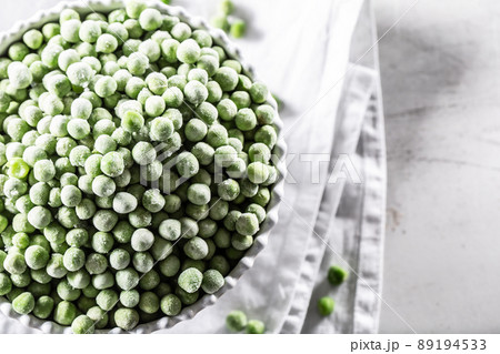 Frozen peas in a white porcelain bowl. 89194533
