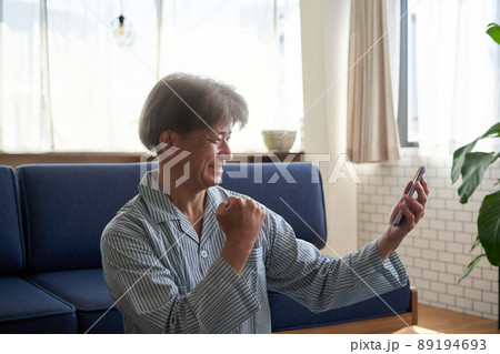 スマホを見て喜ぶ男性 89194693