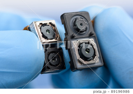 Smartphone camera modules in scientist hands. Different sensor sizes and technology. 89196986