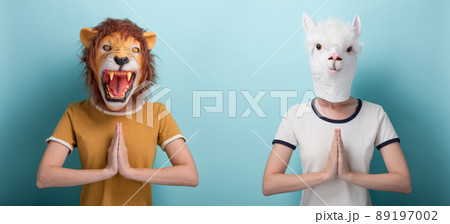 Young woman in lion and alpaca mask hold their hands together in gratitude or prayer sign 89197002