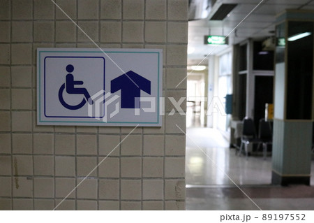 Sign wheelchair way on light wall in building. Sign wheelchair way on light wall in building. 89197552