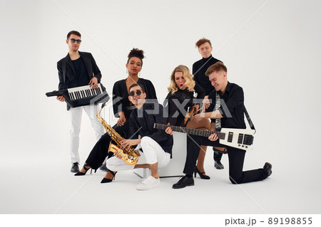 Portrait of diverse group of young people musical band playing with instruments - isolated on white background. Portrait of diverse group of young people musical band playing with instruments - isolated on white background. 89198855