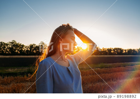 Escapism, getting away from it all, mental health, Stress resilience. Alone Young woman in linen dress walking on mowed wheat field at sunset. Peaceful woman with long hair spending time in nature Escapism, getting away from it all, mental health, Stress resilience. Alone Young woman in linen dress walking on mowed wheat field at sunset. Peaceful woman with long hair spending time in nature 89198892