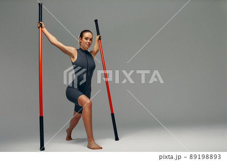 beautiful girl in sports uniform is training kung fu in the studio, fighter athlete, practicing martial arts with a stick beautiful girl in sports uniform is training kung fu in the studio, fighter athlete, practicing martial arts with a stick 89198893