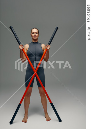 beautiful girl in sports uniform is training kung fu in the studio, fighter athlete, practicing martial arts with a stick beautiful girl in sports uniform is training kung fu in the studio, fighter athlete, practicing martial arts with a stick 89198896