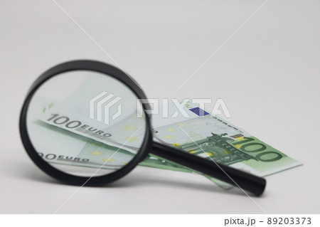 One hundred euro banknotes under magnifying glass, eurozone crisis. 89203373