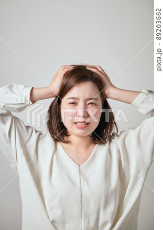 両手で頭を抱える若い女性 両手で頭を抱える若い女性 89203662