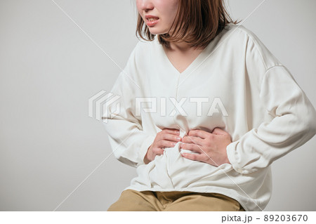 お腹が痛くて手でおさえる若い女性 お腹が痛くて手でおさえる若い女性 89203670