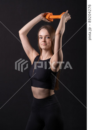 Maiden on background black a . Beautiful with orange dumbbells orange two gym, for shape fitness for fit for female care, happy plus. Chubby big cheerful, figure young overweight doing 89204276