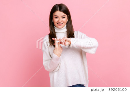 Positive popular woman blogger making hashtag sign with fingers, tagging posts in social networks, wearing white casual style sweater. Indoor studio shot isolated on pink background. Positive popular woman blogger making hashtag sign with fingers, tagging posts in social networks, wearing white casual style sweater. Indoor studio shot isolated on pink background. 89206100