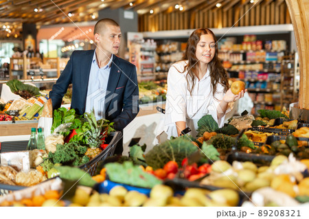 Couple shopping at vegetables department at supermarket Couple shopping at vegetables department at supermarket 89208321