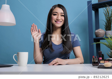 Makeup artist influencer greeting broadcast subscribes while recording content creator for vlogging channel in studio. Beauty vlogger filming make up tutorial advertising products. Cosmetology podcast 89212625