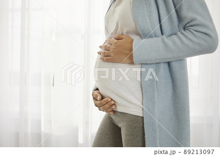 Close up of pregnant tummy of young woman who is in third trimester of pregnancy. Close up of pregnant tummy of young woman who is in third trimester of pregnancy. 89213097