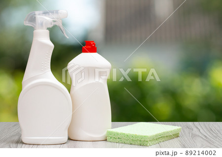 Bottles of dishwashing liquid and sponge on the green background. 89214002