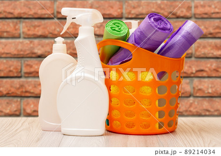 Bottles of dishwashing liquid, basket with garbage bags and sponges. Bottles of dishwashing liquid, basket with garbage bags and sponges. 89214034